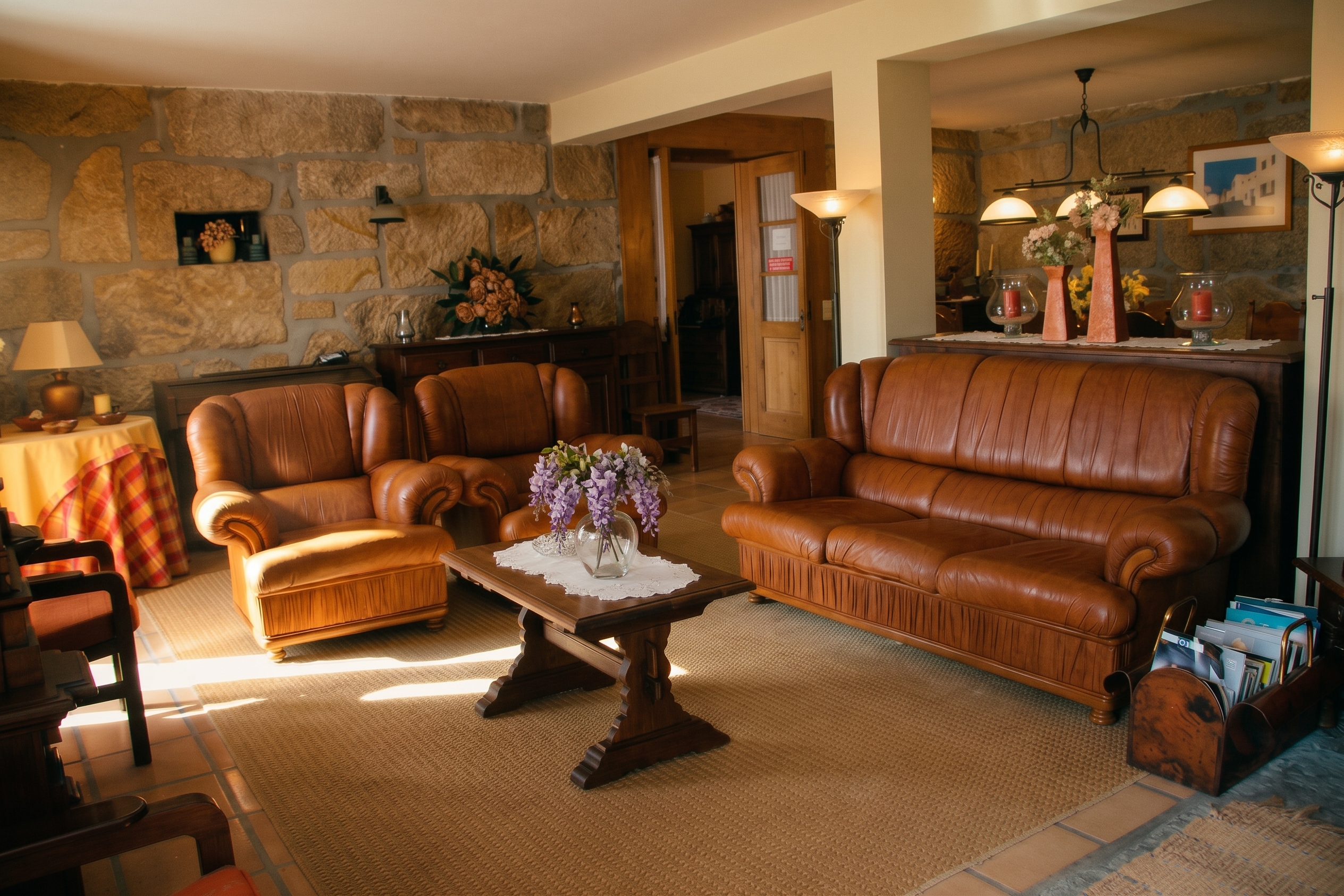 Sala ampla da suite, com paredes de granito, sofás de couro, mesa de madeira lavrada e a sala de jantar ao fundo